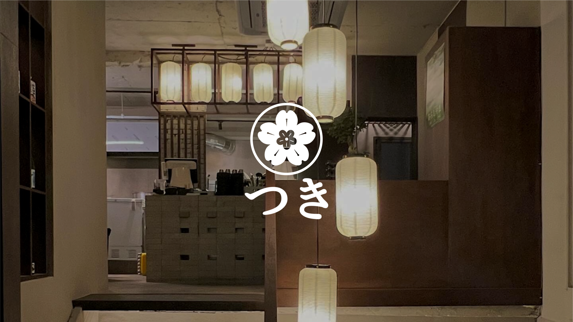 tes design(테스 디자인)이 연출한 이자카야 츠키의 내부 전경으로, 은은한 달빛을 형상화한 전통 종이 등기구와 따뜻한 목재 인테리어가 조화를 이룬 모습